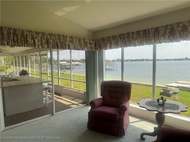 sunroom featuring a sink, a water view, and vaulted ceiling