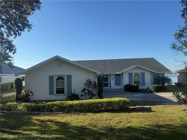 single story home featuring a shingled roof and a front yard