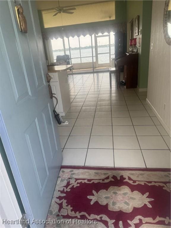 hallway featuring light tile patterned floors and baseboards