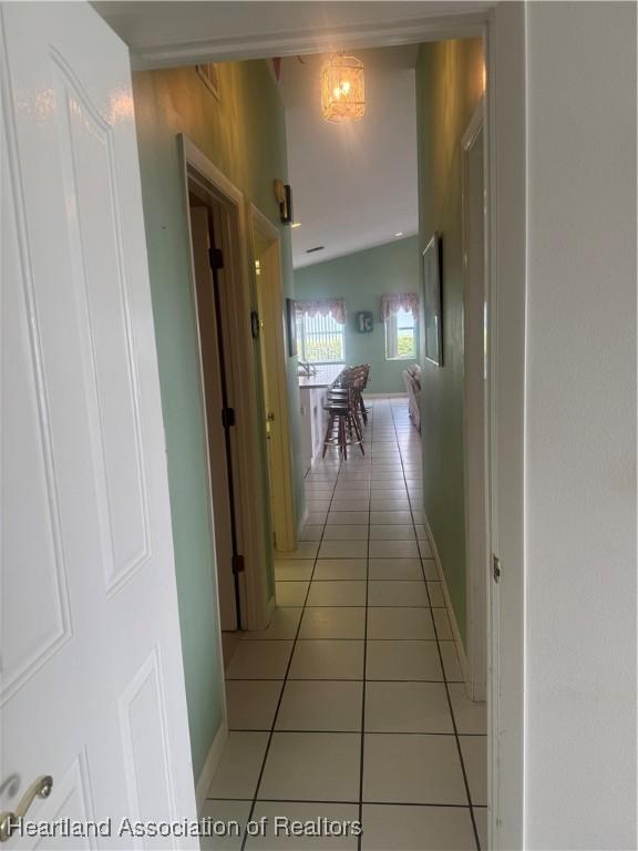 hallway featuring light tile patterned floors and baseboards