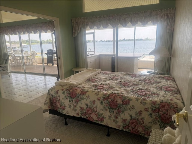 tiled bedroom featuring a water view and access to outside