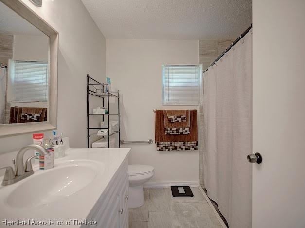 bathroom featuring a shower with shower curtain, a textured ceiling, vanity, and toilet