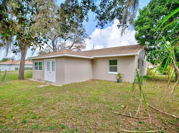 rear view of property featuring a yard