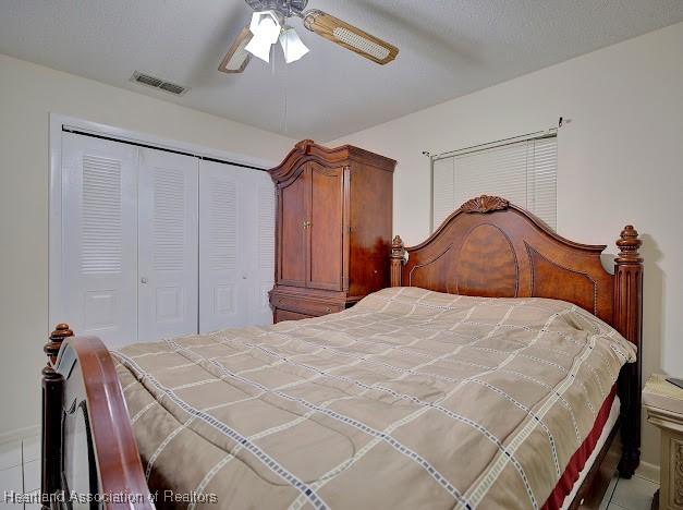 bedroom featuring a textured ceiling, a closet, and ceiling fan