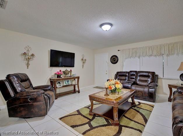 tiled living room with a textured ceiling