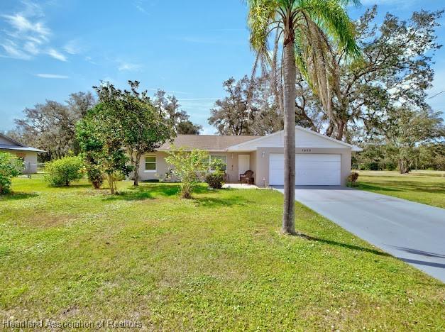 ranch-style house featuring a garage and a front yard