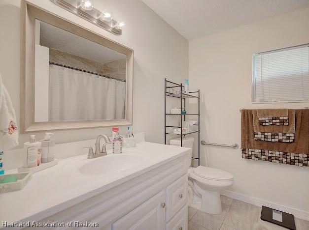 bathroom with tile patterned flooring, vanity, and toilet