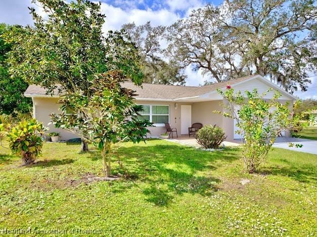 ranch-style house with a front lawn and a patio area