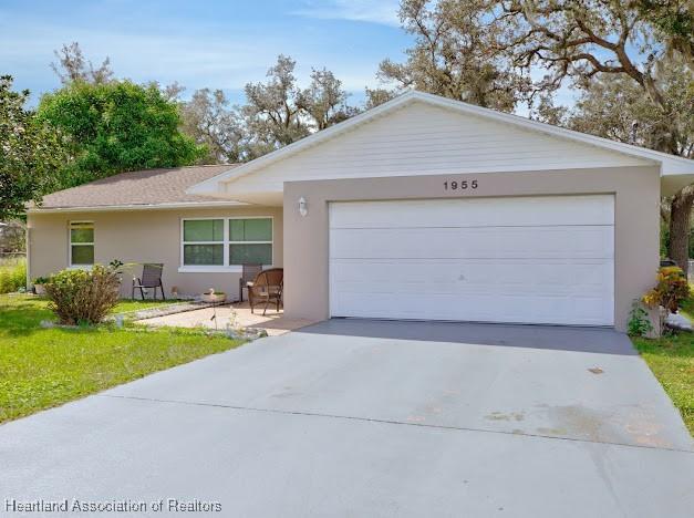 ranch-style house featuring a garage and a front yard