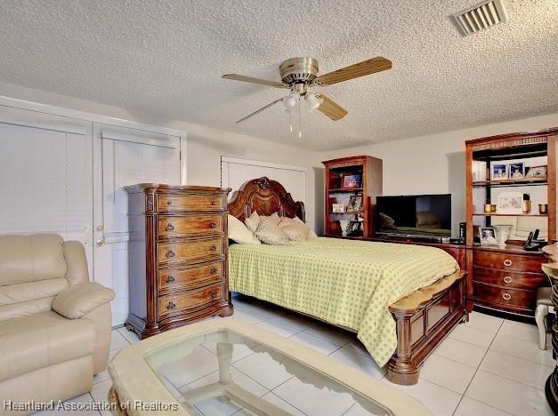 bedroom featuring light tile patterned floors, a textured ceiling, and ceiling fan