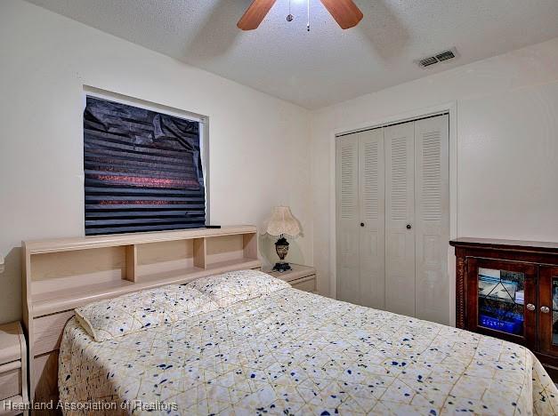 bedroom with ceiling fan, a textured ceiling, and a closet