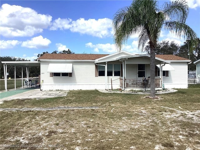 back of property with a yard and a carport