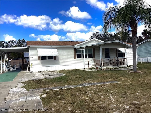 view of front of home with a carport, covered porch, and a front lawn