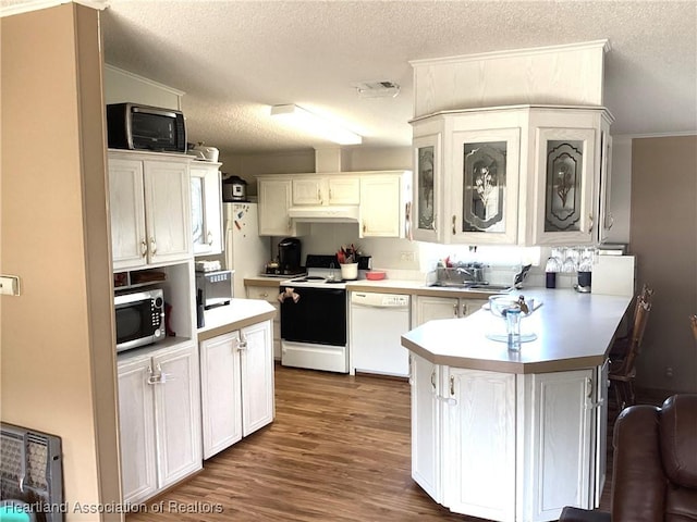 kitchen featuring white appliances, dark wood-type flooring, white cabinets, sink, and a textured ceiling