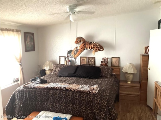 bedroom featuring multiple windows, a textured ceiling, hardwood / wood-style flooring, and ceiling fan