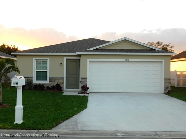 ranch-style house with a garage and a lawn