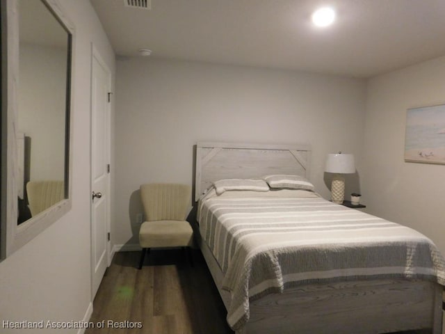 bedroom with dark hardwood / wood-style floors