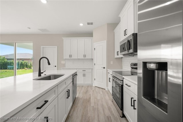 4924 San Lorenzo Dr, Sebring, FL 33872 - kitchen featuring white cabinetry, visible vents, appliances with stainless steel finishes, light countertops, and a sink