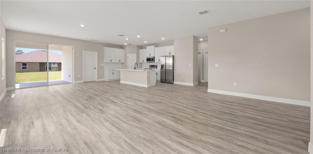 4924 San Lorenzo Dr, Sebring, FL 33872 - unfurnished living room featuring visible vents, recessed lighting, a sink, light wood finished floors, and baseboards