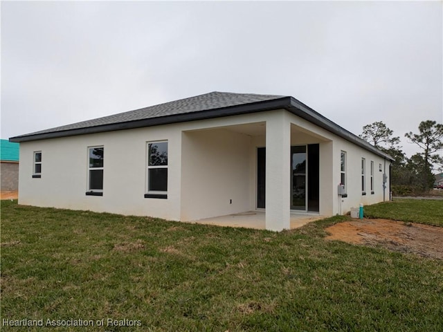 rear view of property featuring a patio and a yard