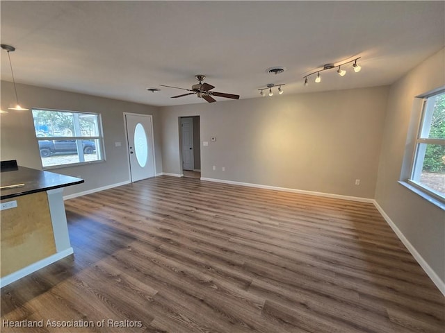 unfurnished living room with ceiling fan and dark hardwood / wood-style flooring