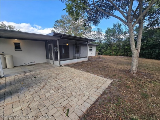 rear view of property featuring a patio and a sunroom