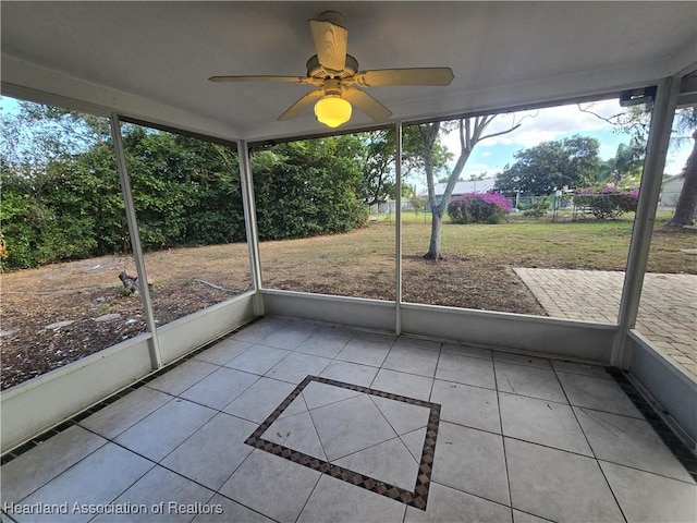 unfurnished sunroom with ceiling fan