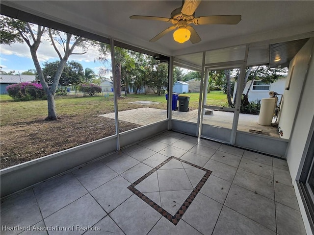 unfurnished sunroom with ceiling fan