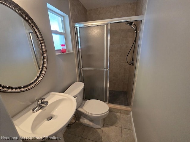 bathroom with toilet, tile patterned floors, an enclosed shower, and sink