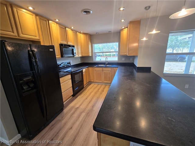 kitchen featuring black appliances, sink, hanging light fixtures, light hardwood / wood-style flooring, and light brown cabinetry