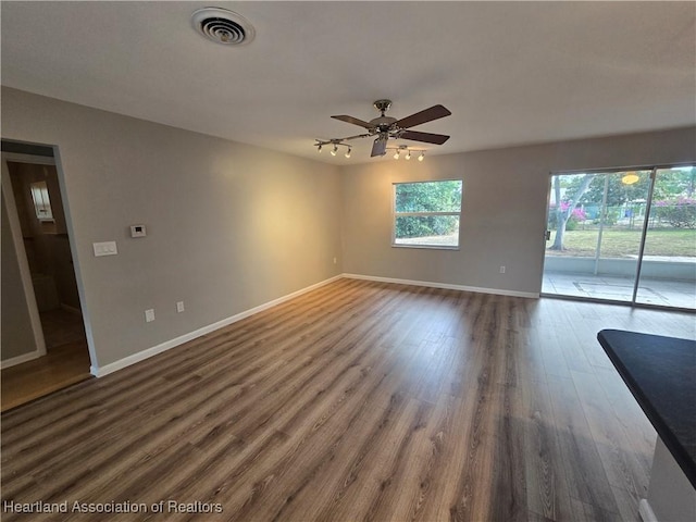 empty room with ceiling fan and dark hardwood / wood-style flooring