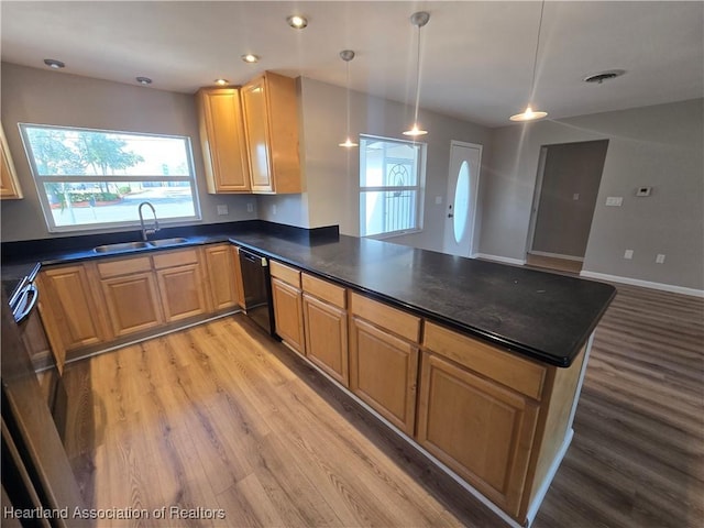 kitchen featuring pendant lighting, sink, light hardwood / wood-style flooring, black dishwasher, and kitchen peninsula