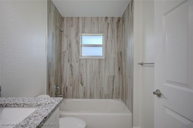 full bathroom featuring toilet, vanity, and tiled shower / bath