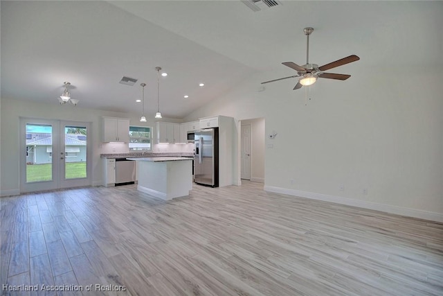 kitchen with a center island, light hardwood / wood-style flooring, decorative light fixtures, white cabinets, and appliances with stainless steel finishes