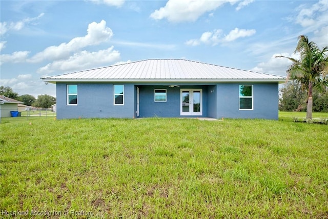 rear view of property with a lawn and french doors