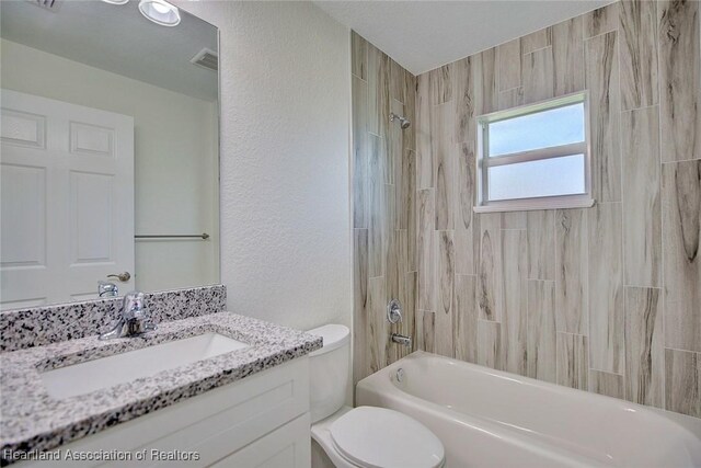 full bathroom featuring vanity, toilet, and tiled shower / bath