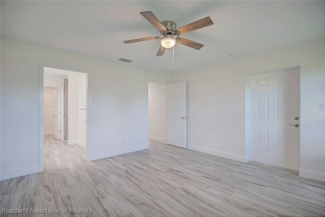 empty room with ceiling fan and light hardwood / wood-style flooring