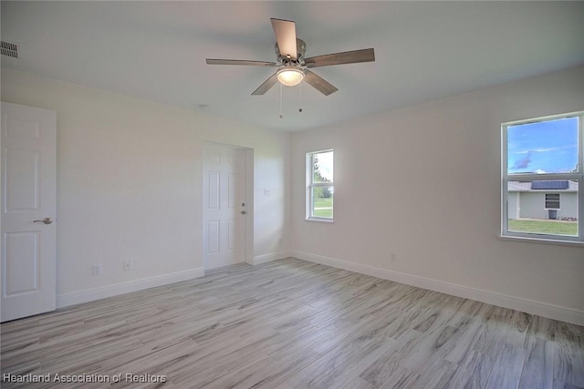 empty room with light hardwood / wood-style floors and ceiling fan