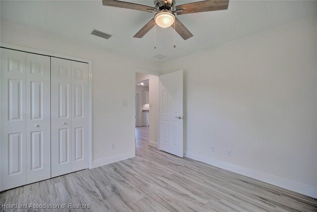 unfurnished bedroom with ceiling fan, light hardwood / wood-style floors, and a closet