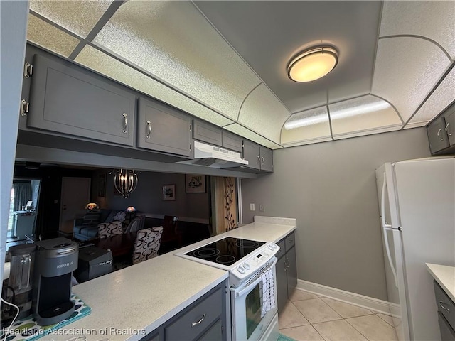 3711 Perugia Ave, Sebring, FL 33872 - kitchen featuring white appliances, gray cabinetry, under cabinet range hood, and light countertops