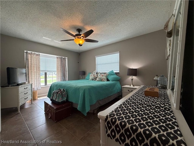 3711 Perugia Ave, Sebring, FL 33872 - bedroom with multiple windows, a ceiling fan, a textured ceiling, and dark tile patterned floors