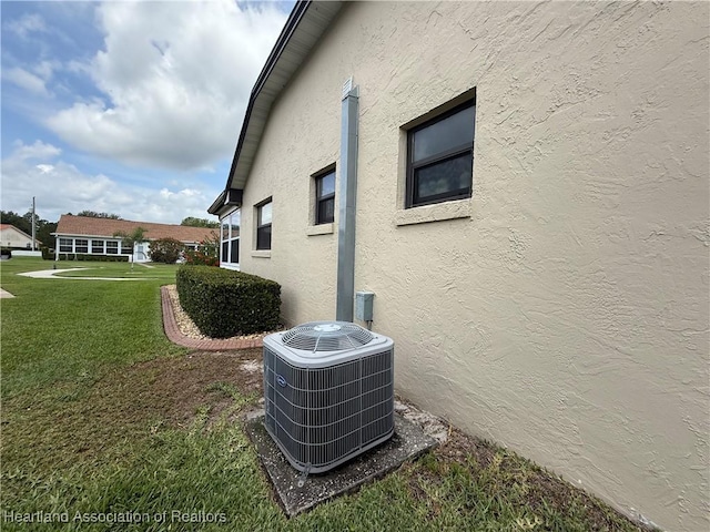 3711 Perugia Ave, Sebring, FL 33872 - view of side of property featuring central AC unit, stucco siding, and a lawn