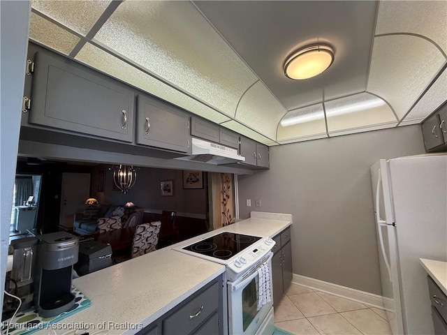 3711 Perugia Ave, Sebring, FL 33872 - kitchen featuring white appliances, gray cabinets, under cabinet range hood, light countertops, and baseboards