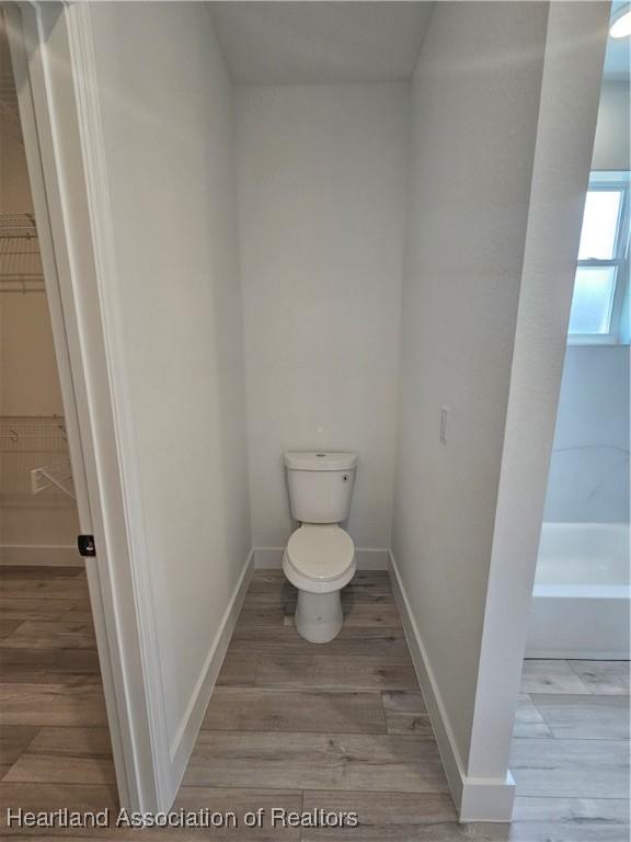 bathroom featuring hardwood / wood-style flooring and toilet