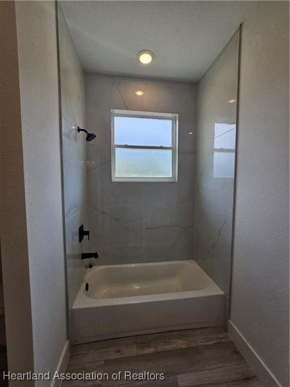 bathroom featuring tiled shower / bath combo and wood-type flooring