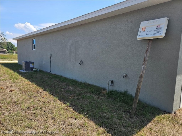 view of property exterior featuring central AC unit and a yard