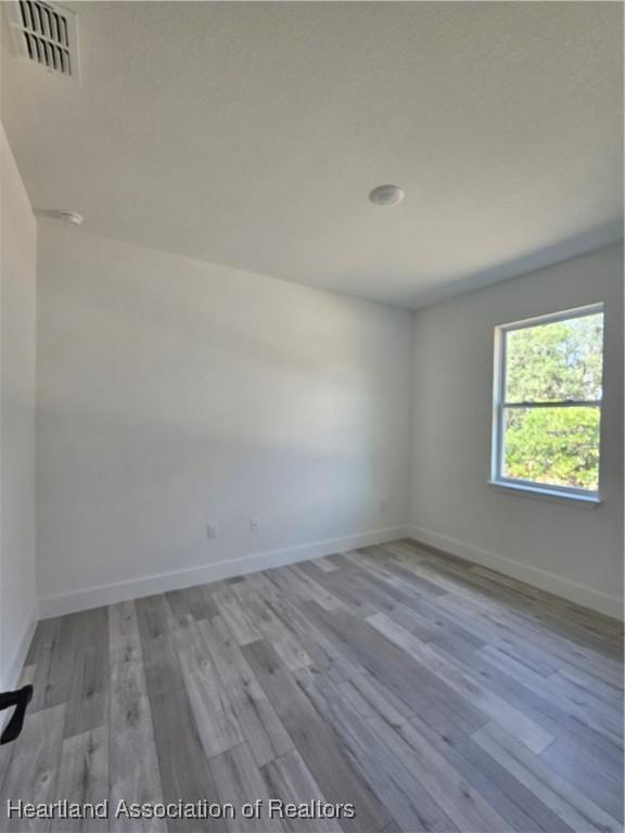 spare room with light hardwood / wood-style flooring