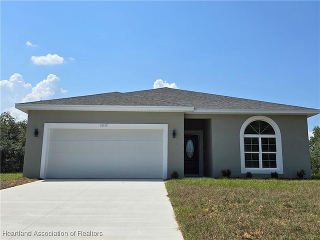 single story home featuring a garage and a front yard