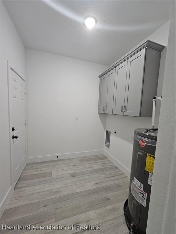 washroom featuring electric water heater, cabinets, light wood-type flooring, and hookup for an electric dryer