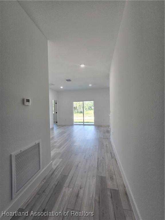 corridor with hardwood / wood-style flooring